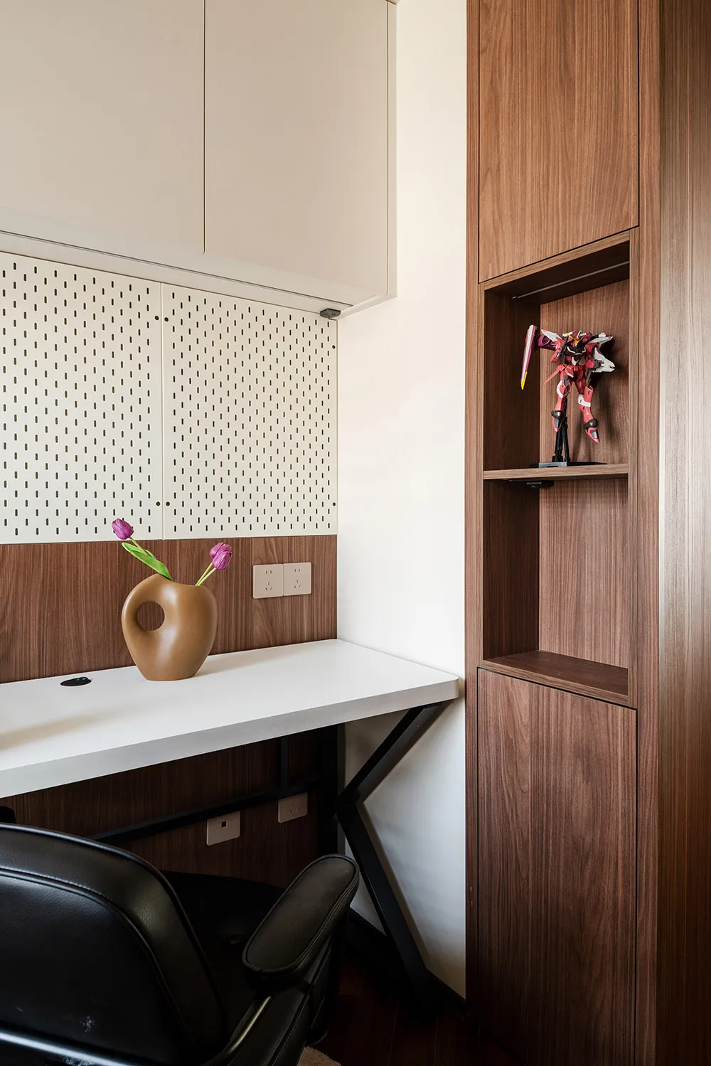 Office space with a wooden desk, bookshelf, and purple flowers in a vase, creating a professional and organized atmosphere