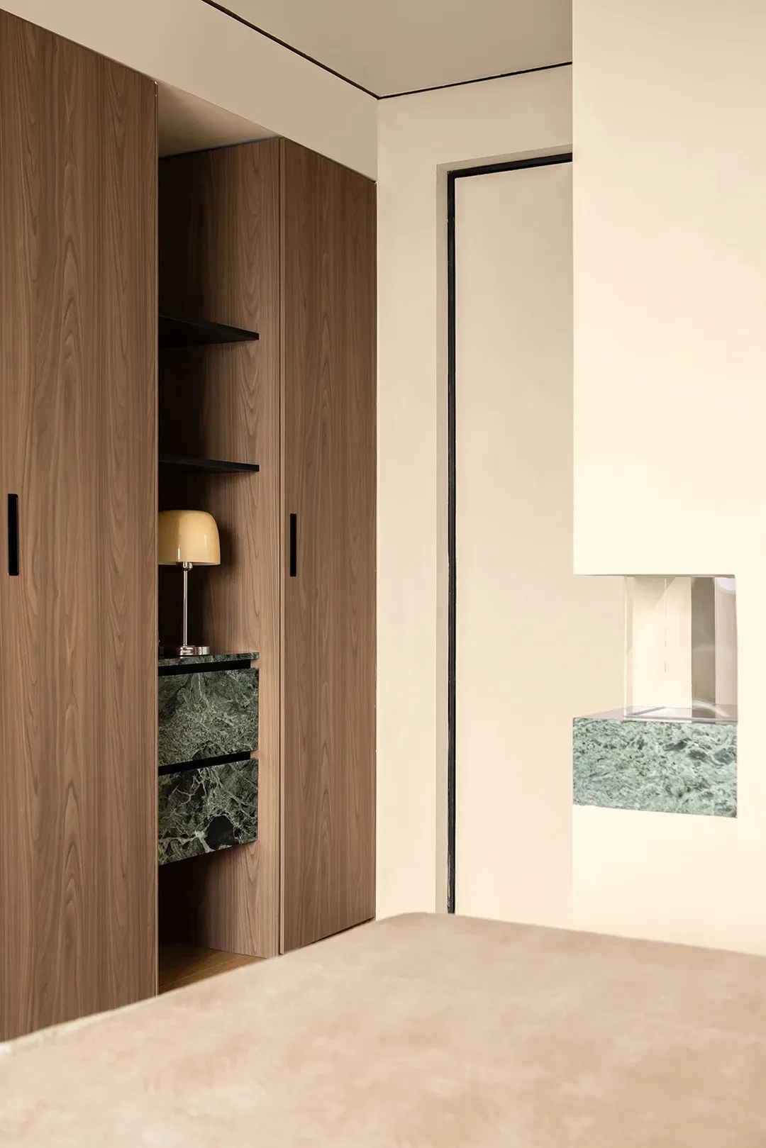 A wooden cabinet with a marble countertop, two lamps, and a well-lit room
