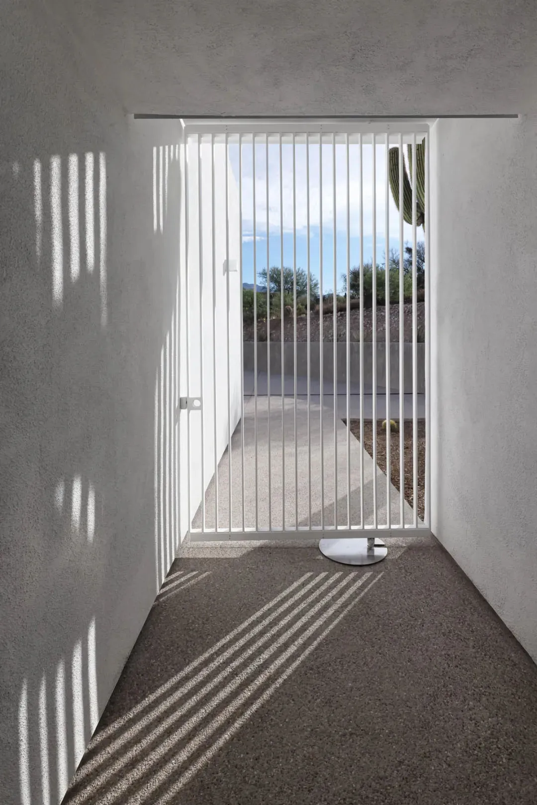 A patio area with a dining table and metal gate, creating a welcoming outdoor space for socializing and relaxation