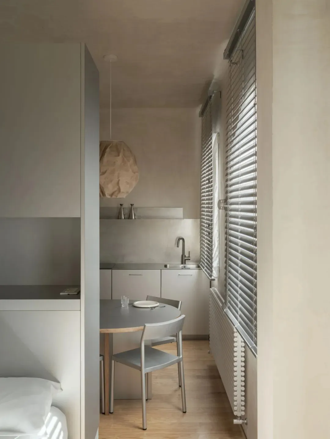 Cozy open kitchen with a dining table, chairs, and a sink, featuring a bowl and a bottle, with a focus on functionality and comfort