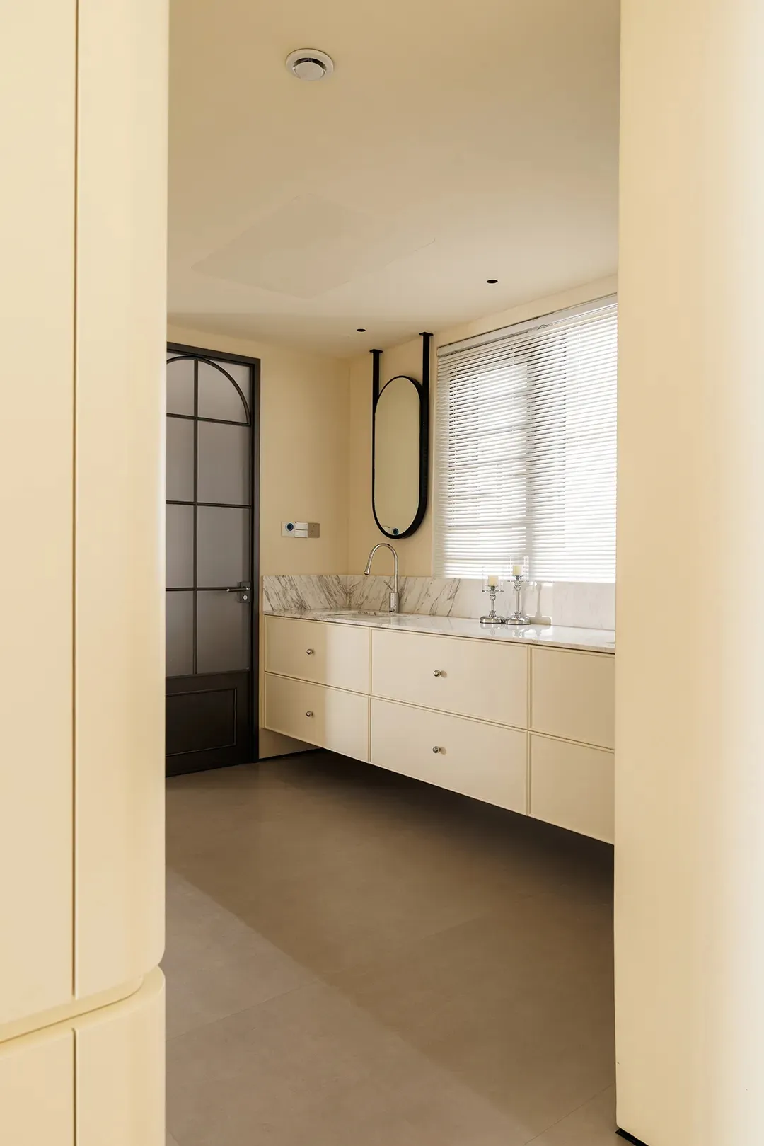 Clean modern bathroom with a sink, mirror, and shower, featuring two bottles on the countertop