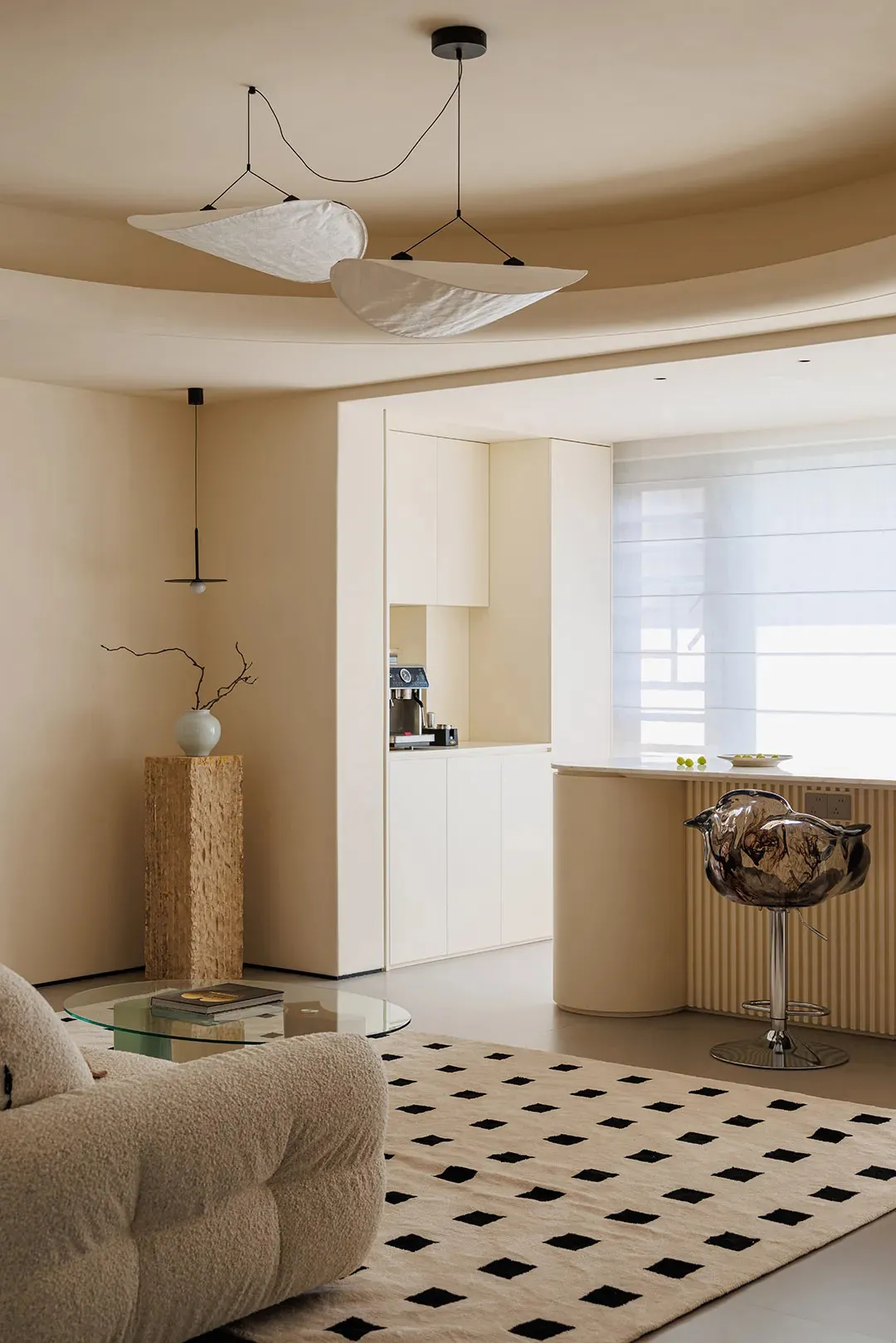 Open living space with a combined kitchen, dining, and living area featuring couches, a chair, coffee table, refrigerator, dining table, and various decorative items in a bright and inviting atmosphere with natural light