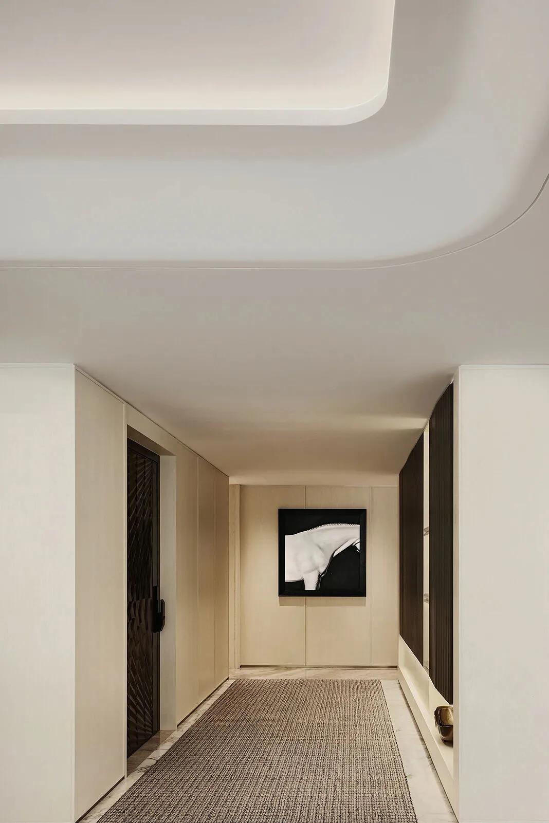 A well-lit office hallway with white walls, two framed pictures, and a clean atmosphere