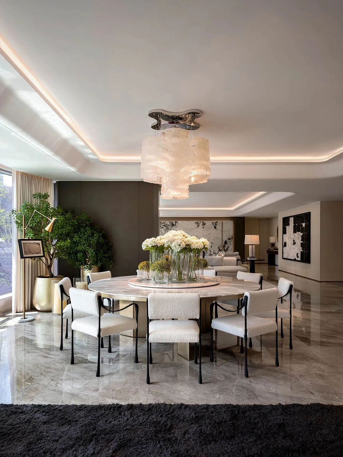Sophisticated dining space with a large table, potted plants, and a modern chandelier