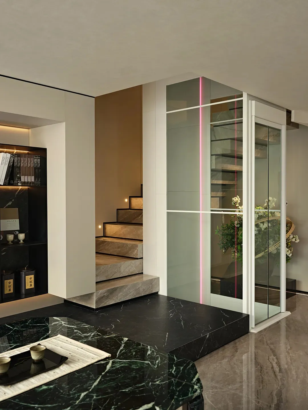 Open modern living space with a glass door, marble stairs, a bookshelf, and a cozy atmosphere