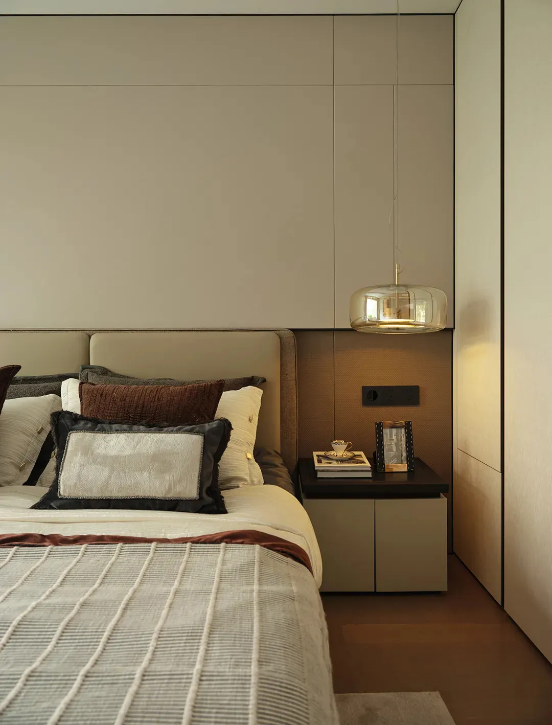 Cozy bedroom with a large bed, white bedding, and two lamps, set against a gray wall with brown accents