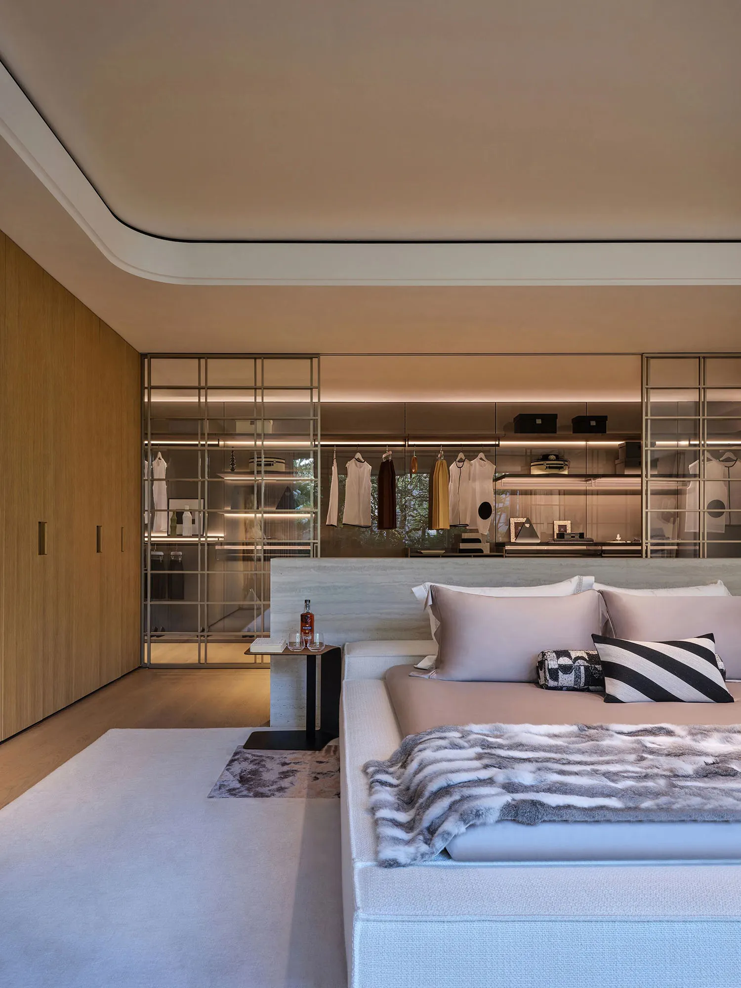 A large white bedroom with a king-size bed, two nightstands, two dressers, and decorative bottles, creating a clean and inviting atmosphere