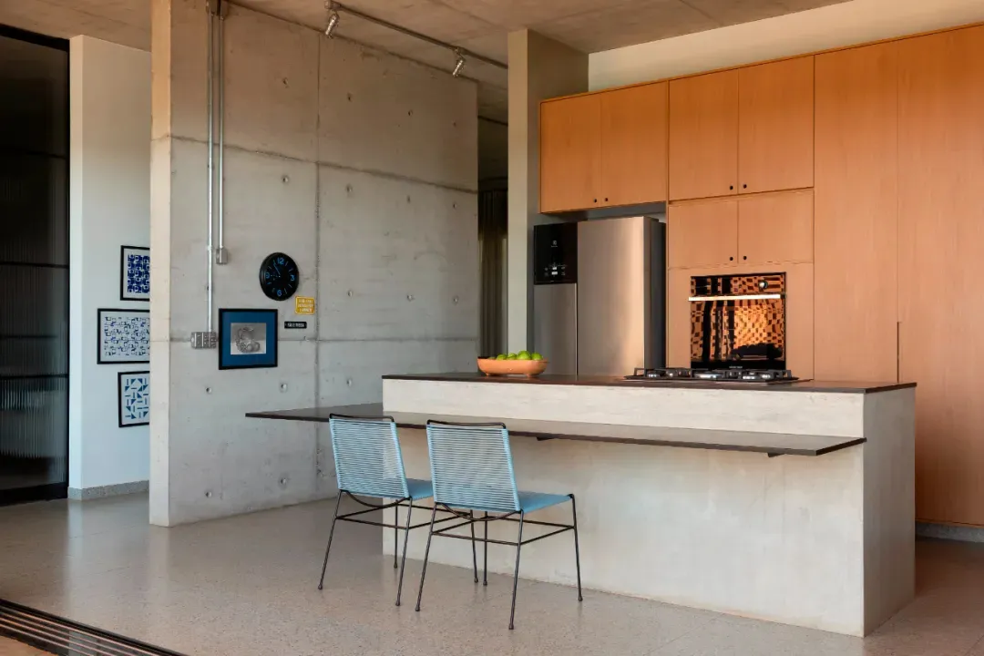 Bright modern kitchen with a countertop island, white cabinets, stainless steel appliances, and a clock on the wall