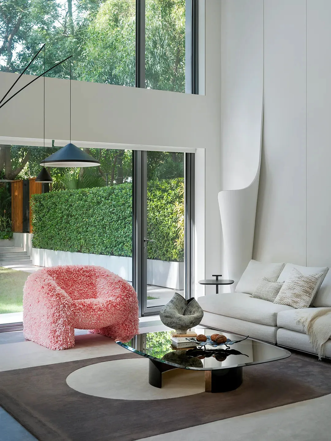Open living area with a white couch, chairs, dining table, and natural light from a glass door leading to a patio
