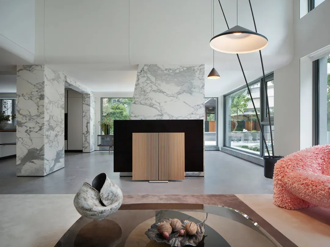 Open living area with a fireplace, potted plants, dining table, and modern kitchen elements