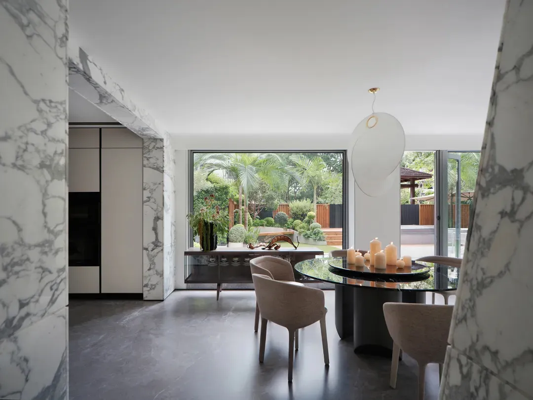 Open concept dining and kitchen space with a glass door, circular dining table, and modern kitchenette