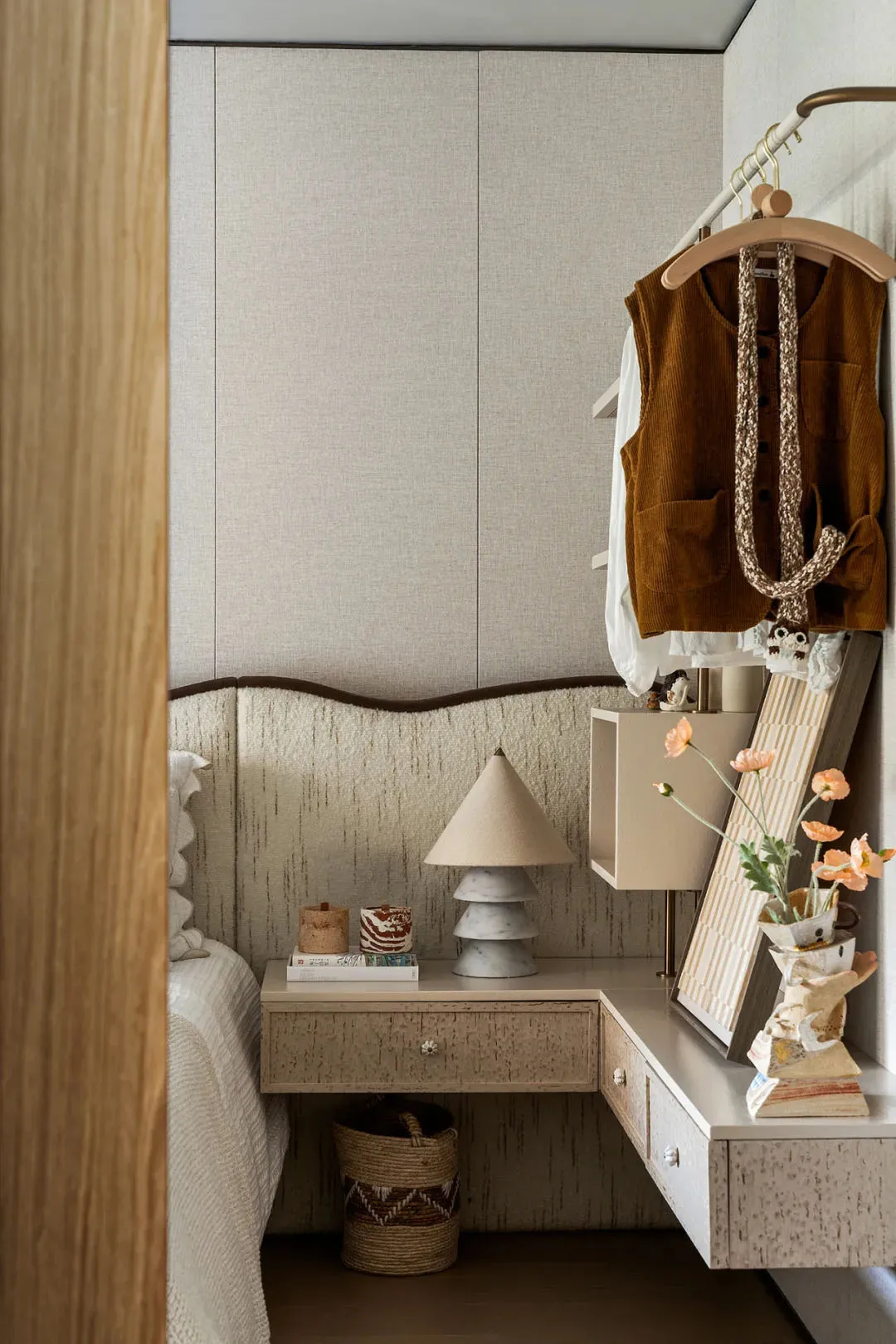 Cozy bedroom with a bed, dressers, a mirror, and books, creating a warm and inviting atmosphere