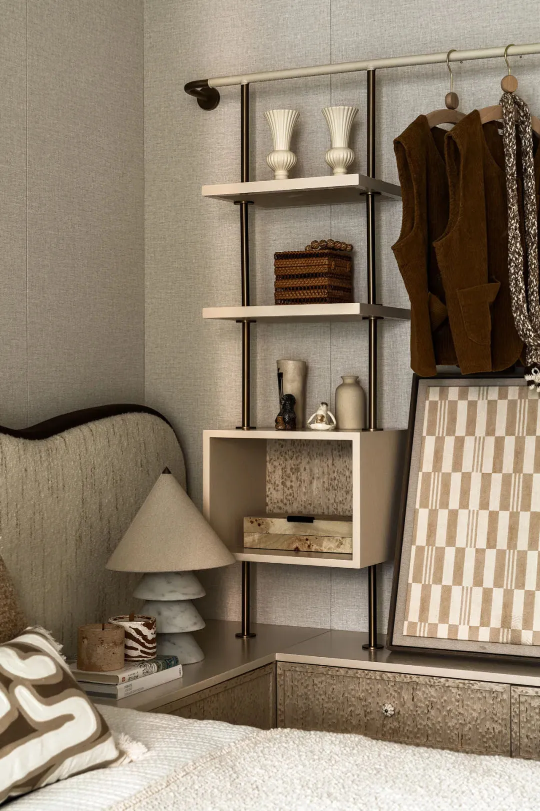 A cozy bedroom sitting area with two beds, a couch, chair, and decorative items such as vases, bottles, and books, creating a warm and inviting atmosphere