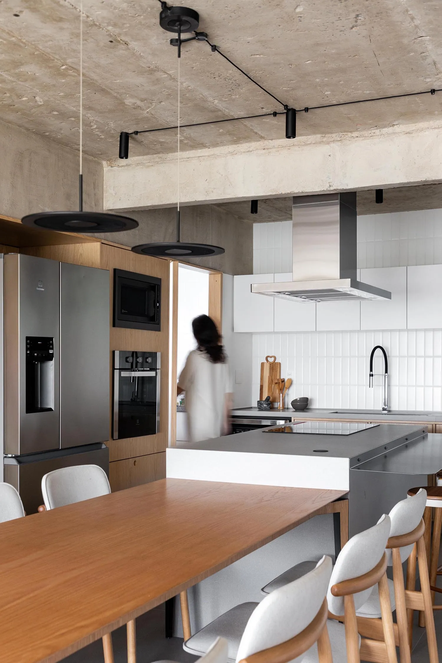 Modern kitchen with a dining table, chairs, appliances, and ample storage, set in a functional and comfortable space