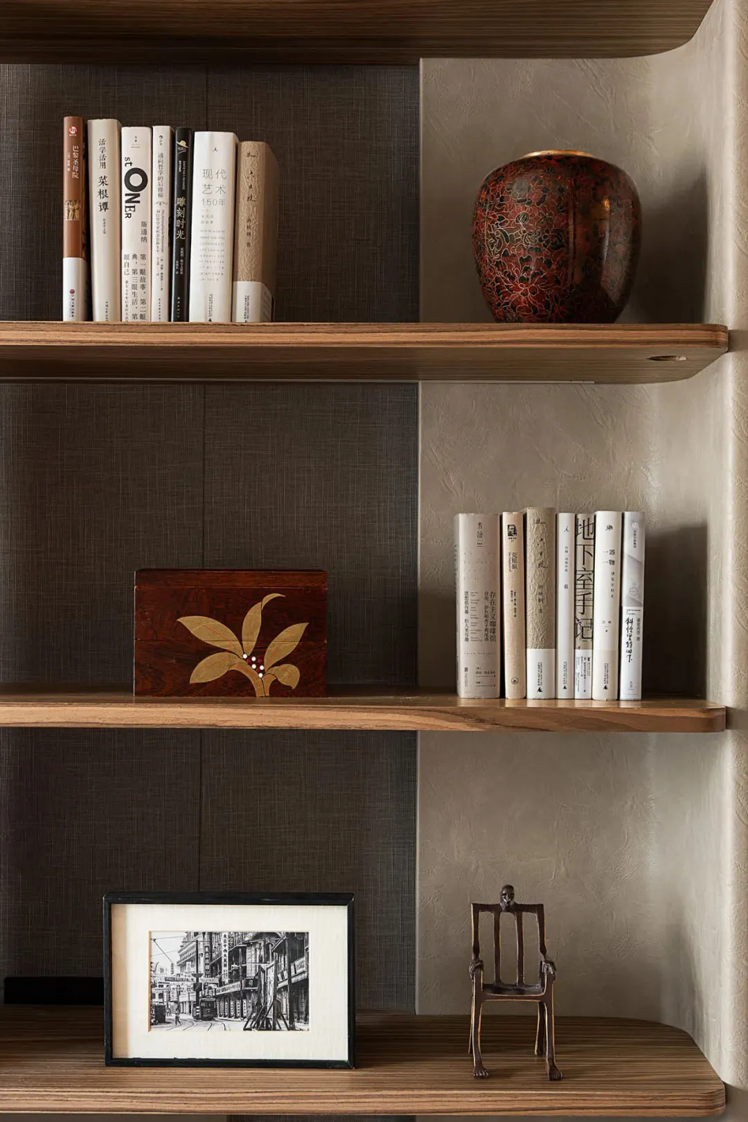 A wooden bookshelf filled with various books of different sizes, arranged in an organized manner, creating a cozy and intellectual environment