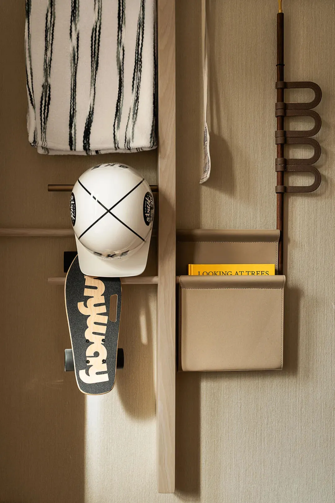 A well-organized storage area with wooden shelves, featuring books, skateboards, and hats, with a functional and organized appearance