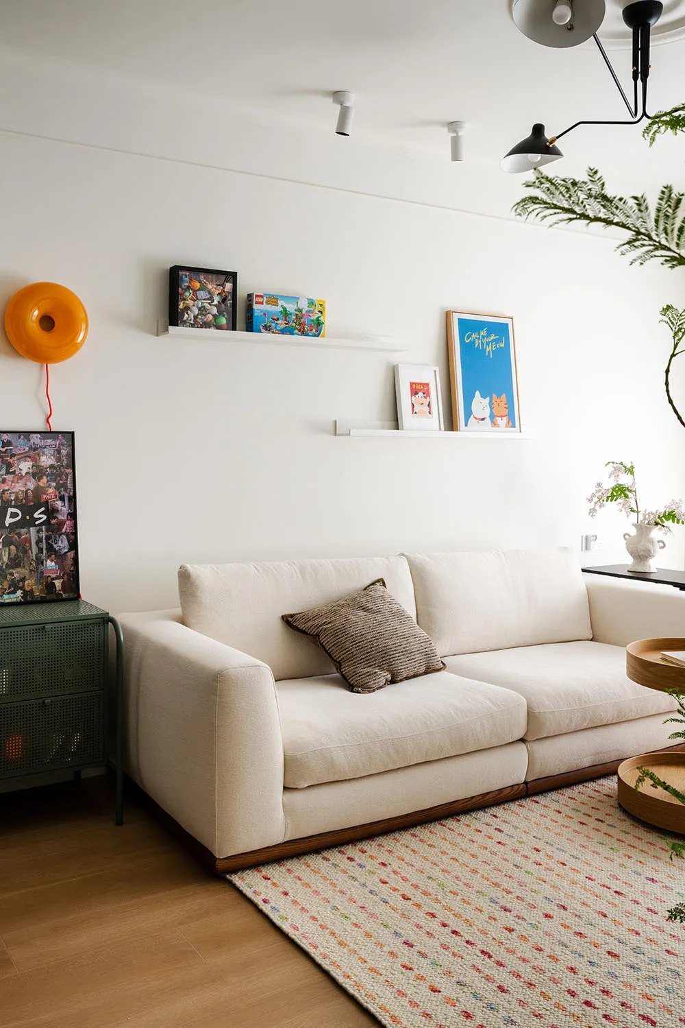 Cozy living room with a white couch on a hardwood floor, surrounded by potted plants and decorative vases