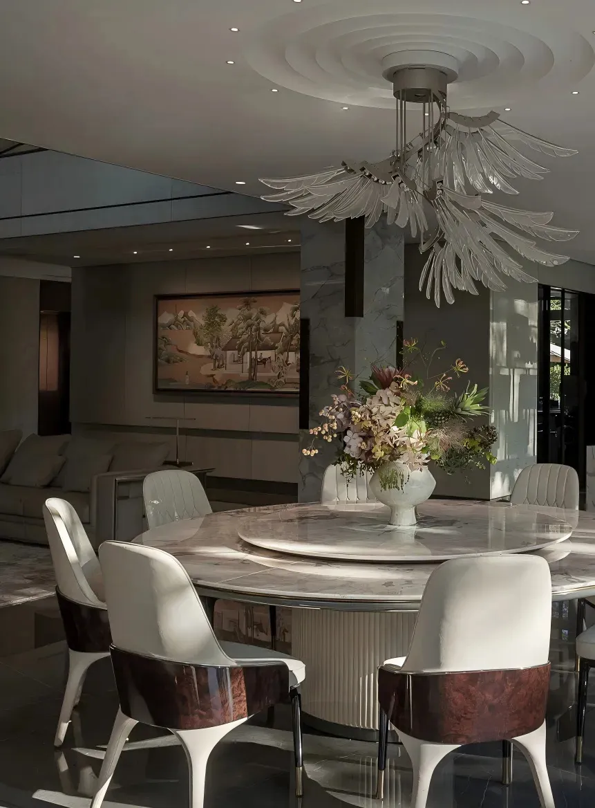 A well-designed living area with a dining table surrounded by chairs, a vase, and a couch, creating a comfortable seating arrangement