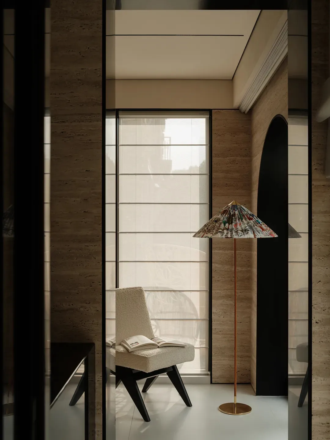 A modern living area with a chair near a window, stone walls, and a calm atmosphere