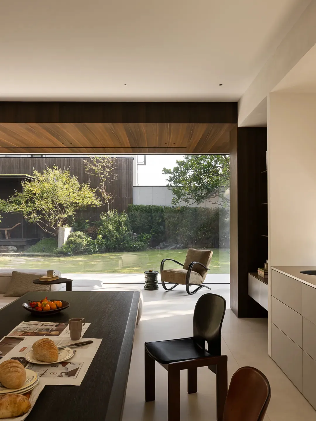 Open living area with wooden floors, white walls, and a mix of furniture and decorative items