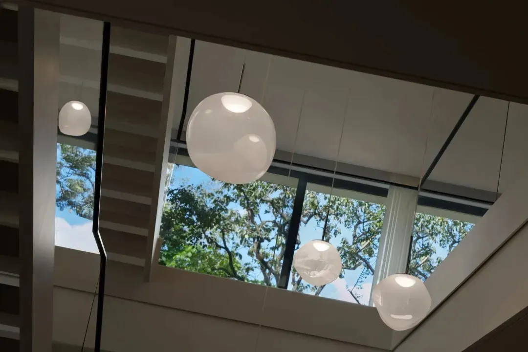 Open modern space with suspended lights, natural light, and two windows