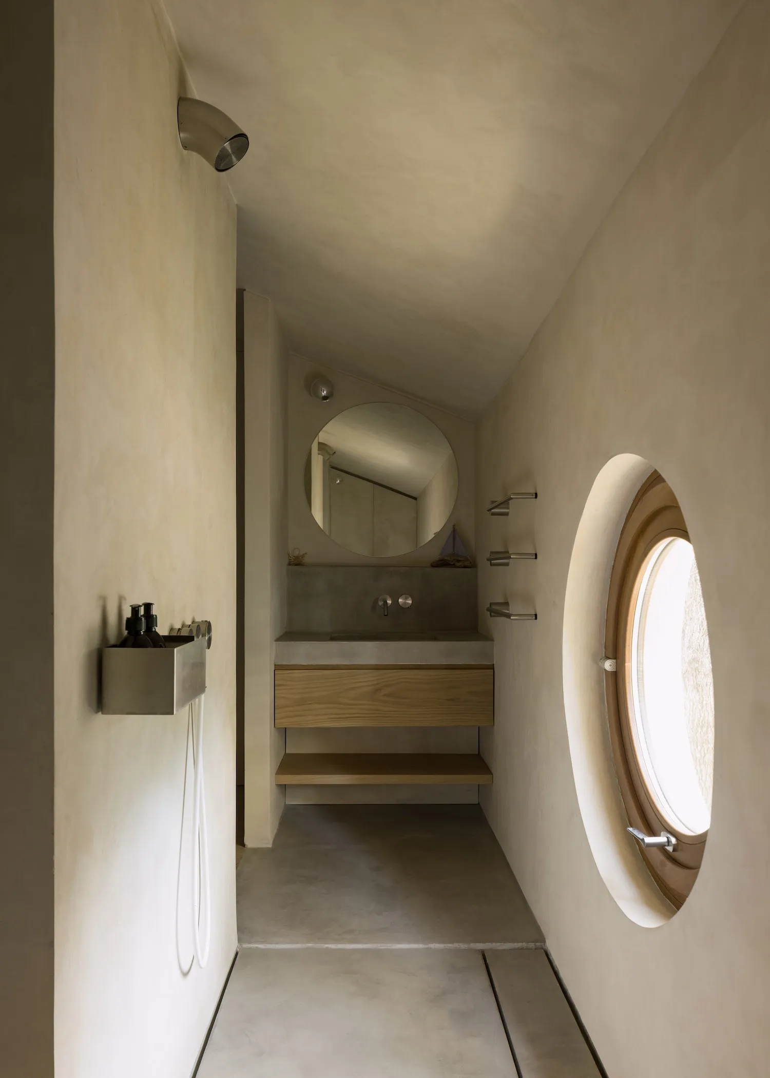 A modern bathroom with two sinks under a large mirror, a glass shower door, and white walls with grey tiles, creating a bright and inviting atmosphere