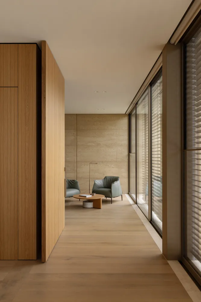 Open living area with wooden walls, a dining table, and natural light from windows