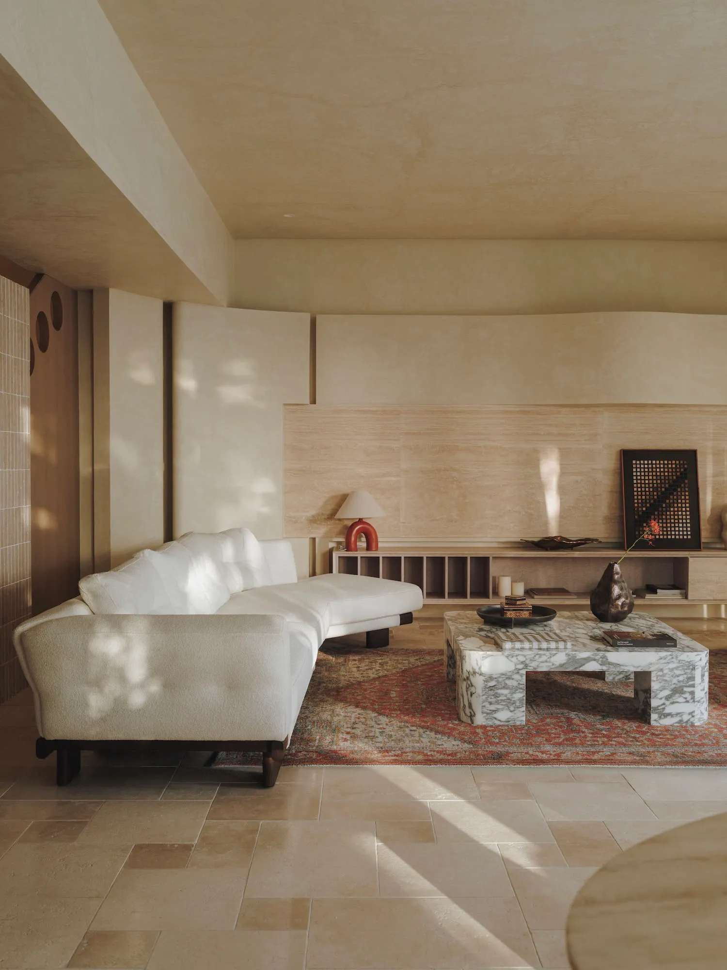 Cozy living area with a white couch, wood paneling walls, a rug, and a dining table