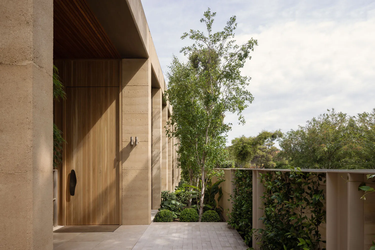 A modern house with multiple rooms, concrete walls, large windows, and potted plants, conveying a sense of luxury and sophistication