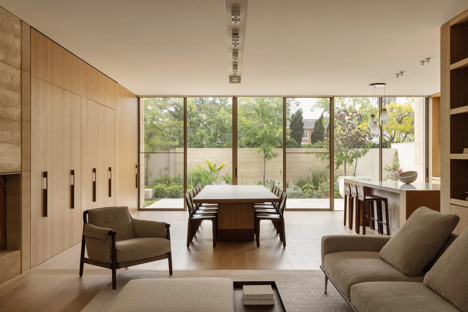 A well-lit open concept living area with a dining table and chairs, a couch, and natural light from windows