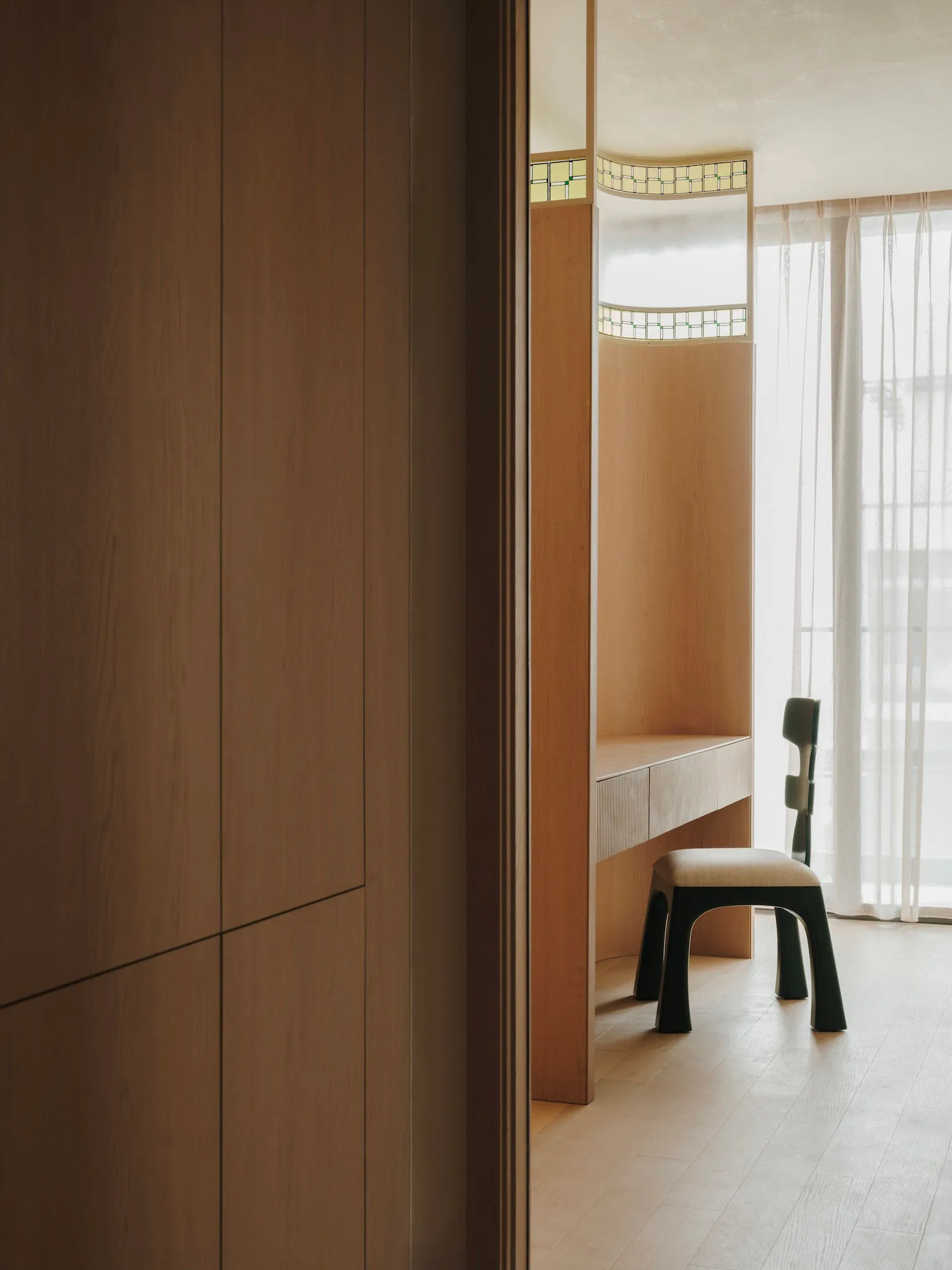 Small room with wooden walls and floors, featuring a desk between two chairs, creating a warm and inviting workspace