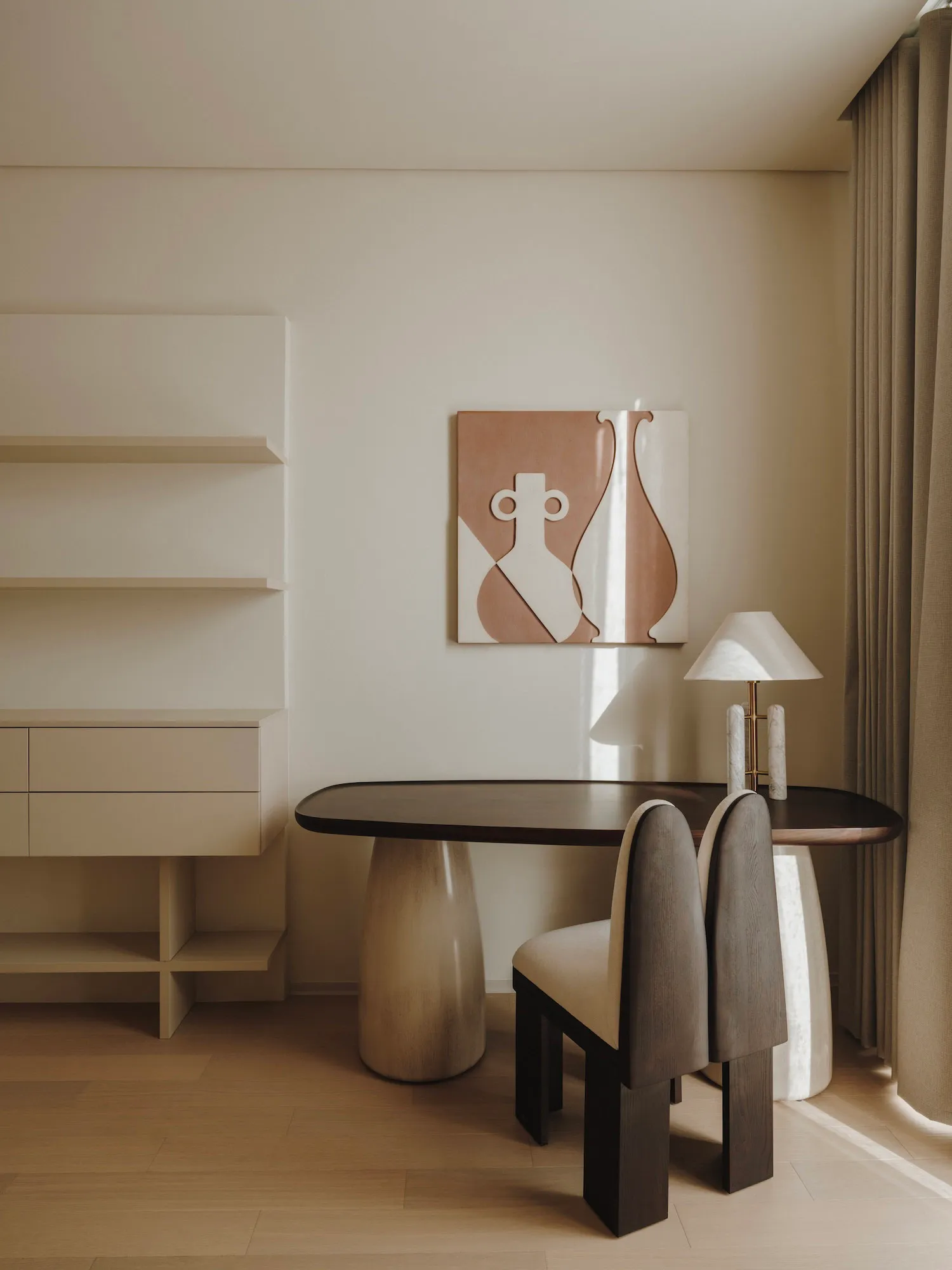 A well-lit dining area with a wooden table and modern chairs, surrounded by a book and suggesting a reading nook