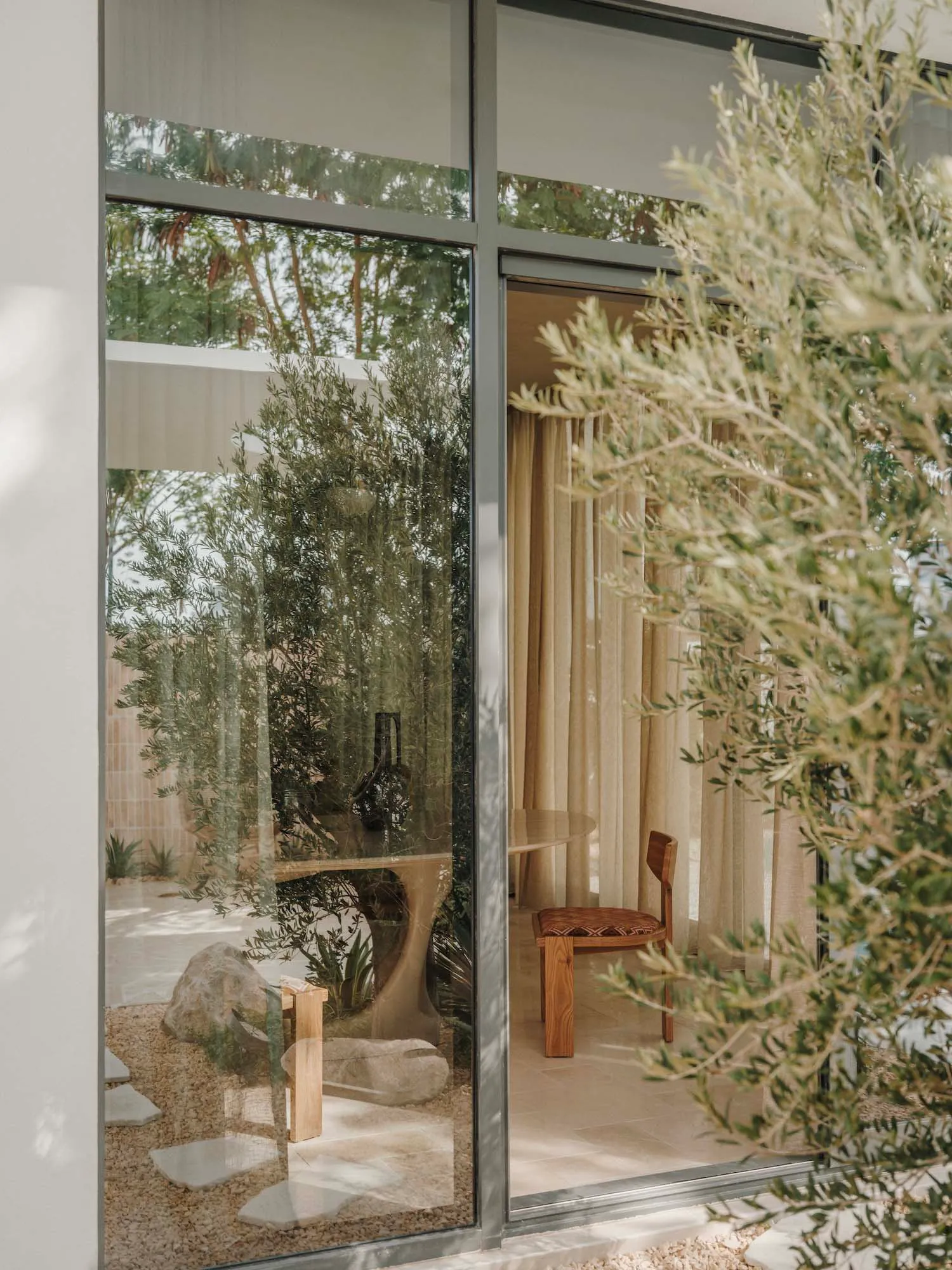 Bright and inviting living area with a large window, two chairs, a dining table, and decorative elements