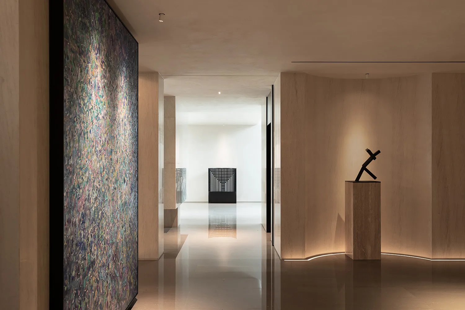 Empty modern hallway with white walls, two large paintings, and bright lighting