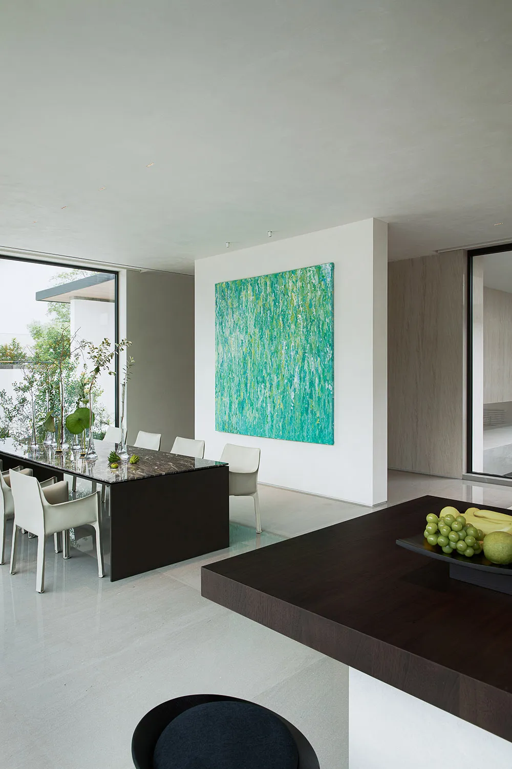 Elegant dining space with a large painting, wine glasses, and a dining table surrounded by chairs