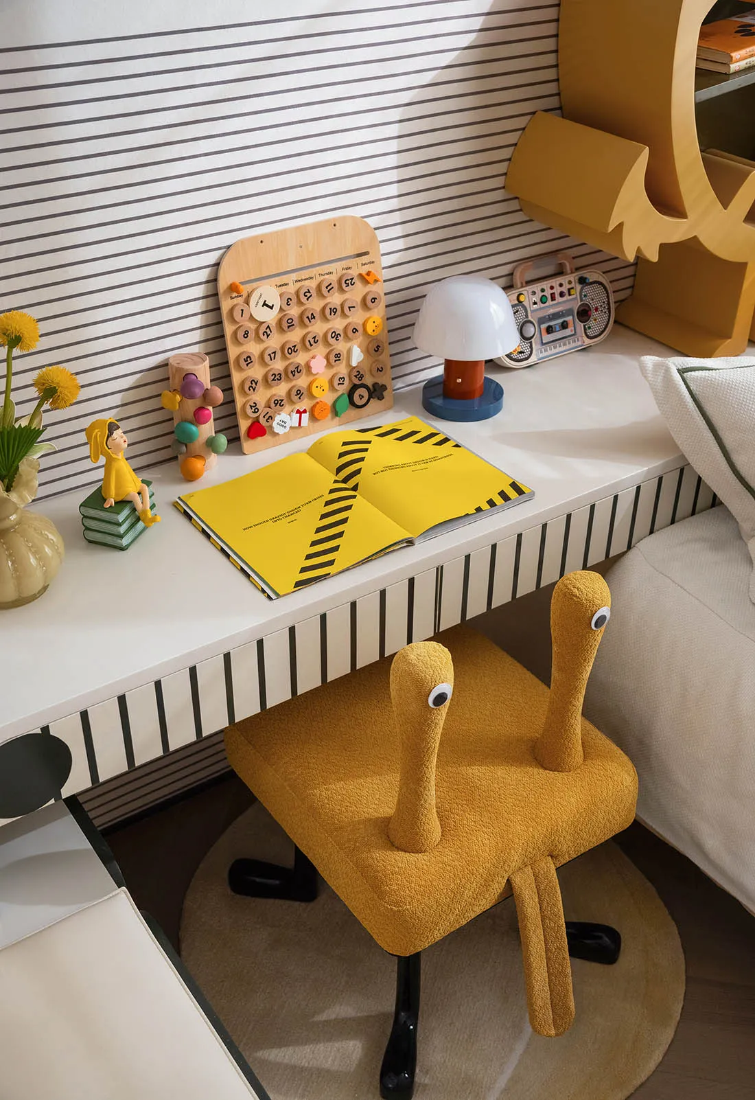 A child's bedroom with a yellow chair, desk, books, toys, and vases, creating a cozy atmosphere