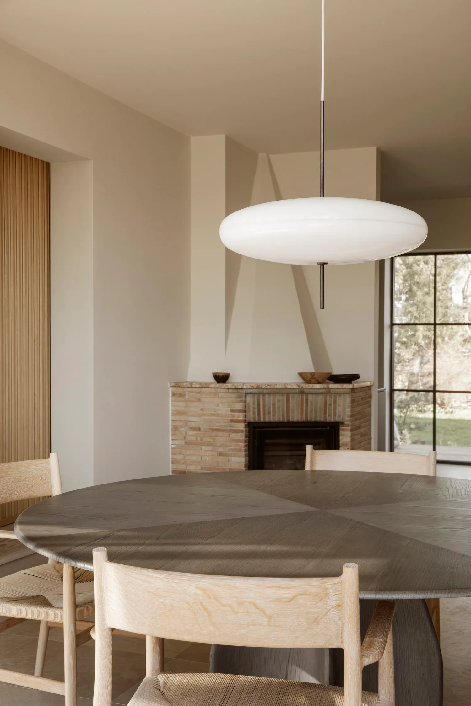 A cozy dining area with a wooden table and chairs, a fireplace, and a warm atmosphere