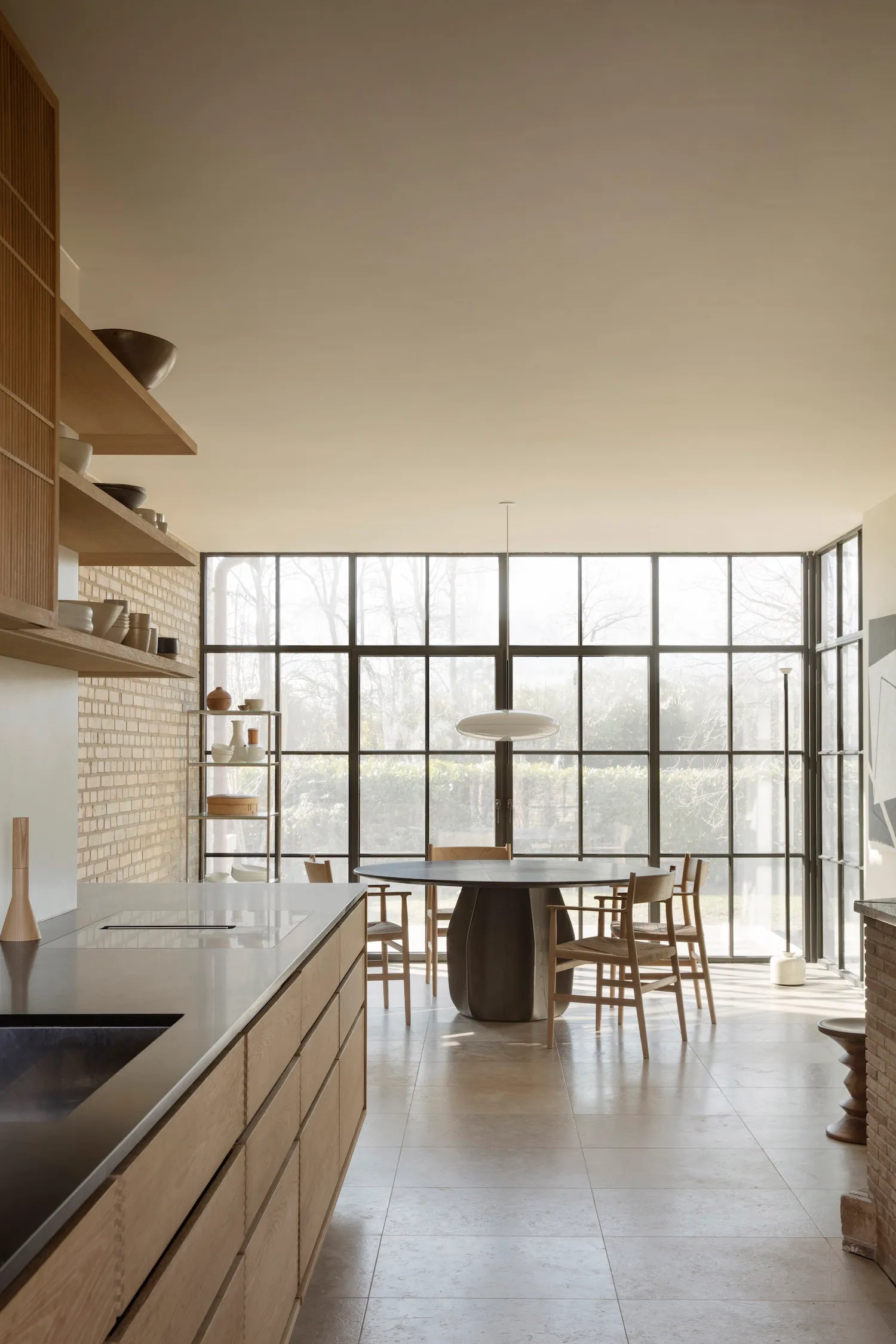 A warm and inviting kitchen and dining area with a large window, comfortable seating, and functional kitchen features