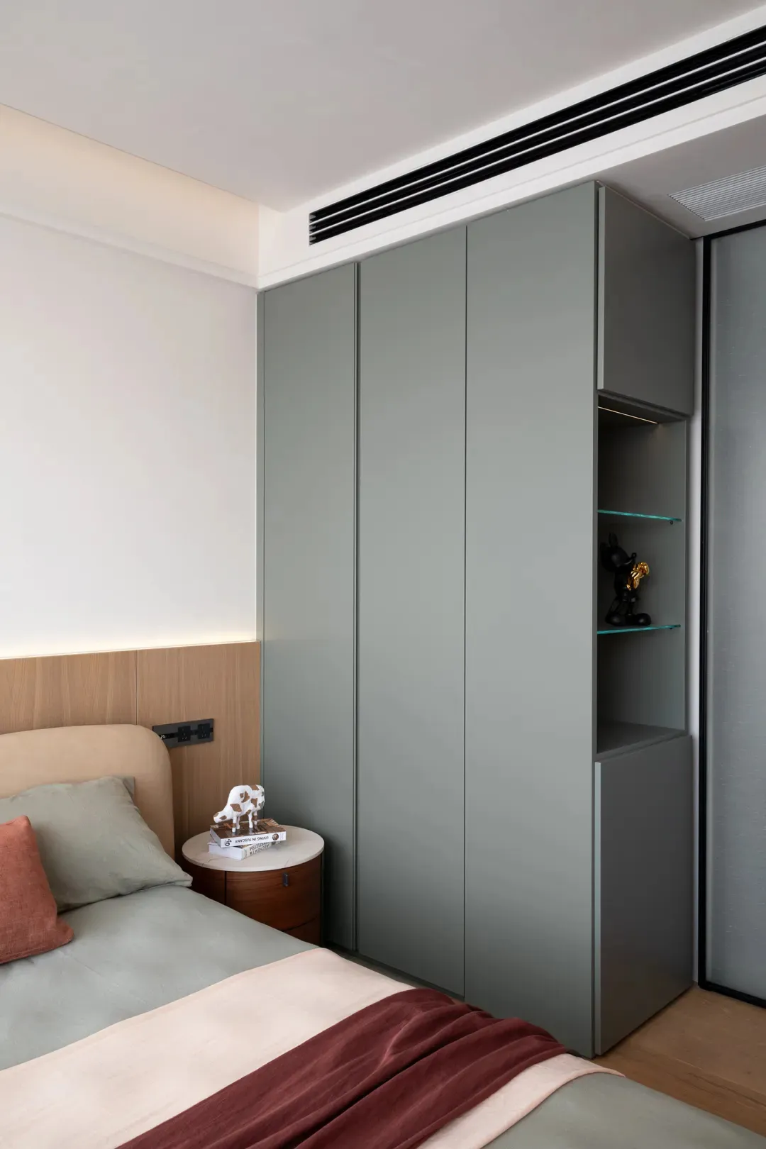Cozy bedroom with a gray color scheme, featuring a bed, dresser, chairs, and a small table, with dim lighting