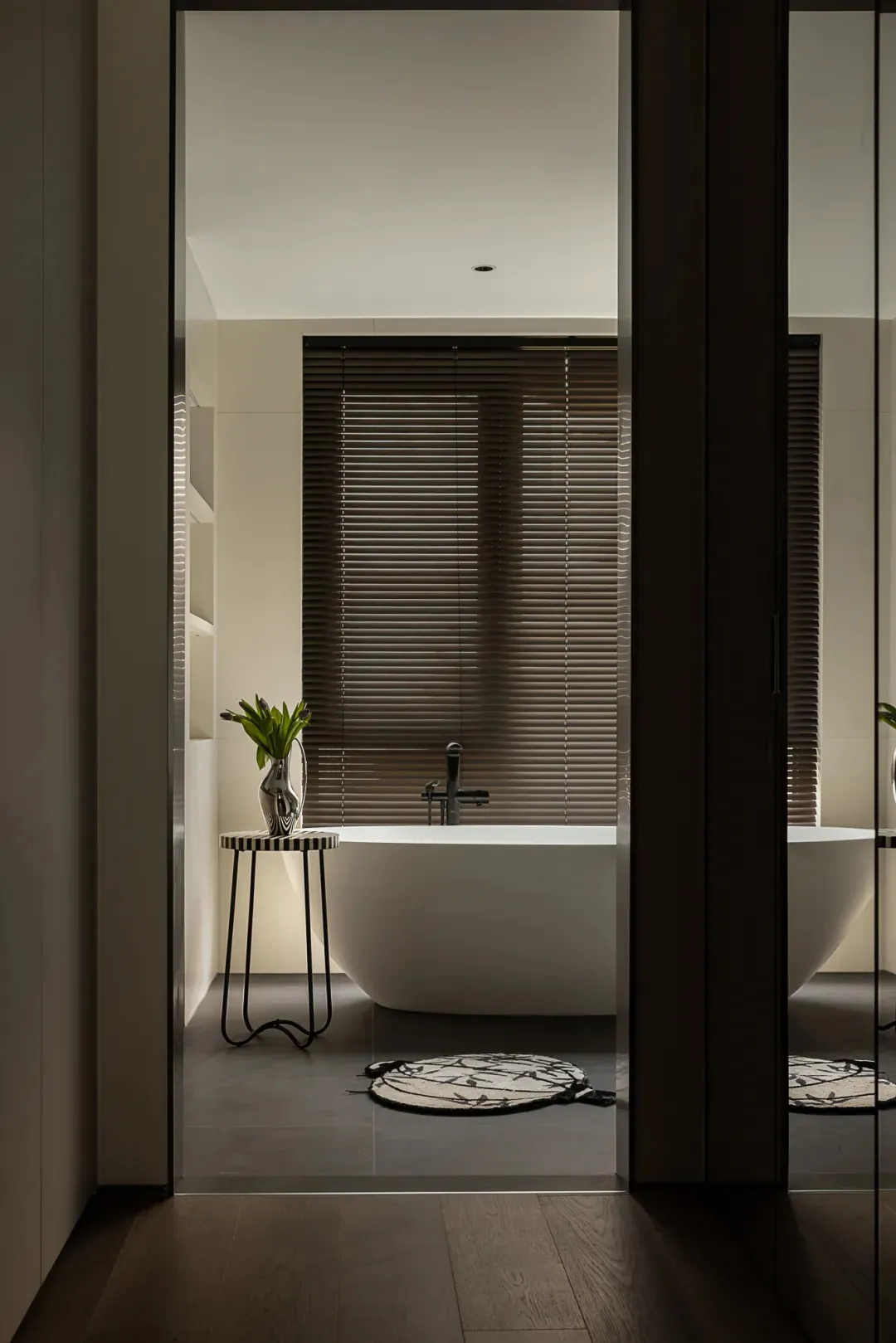 Bathroom with a white bathtub next to a window, featuring two vases and a calm atmosphere with natural light
