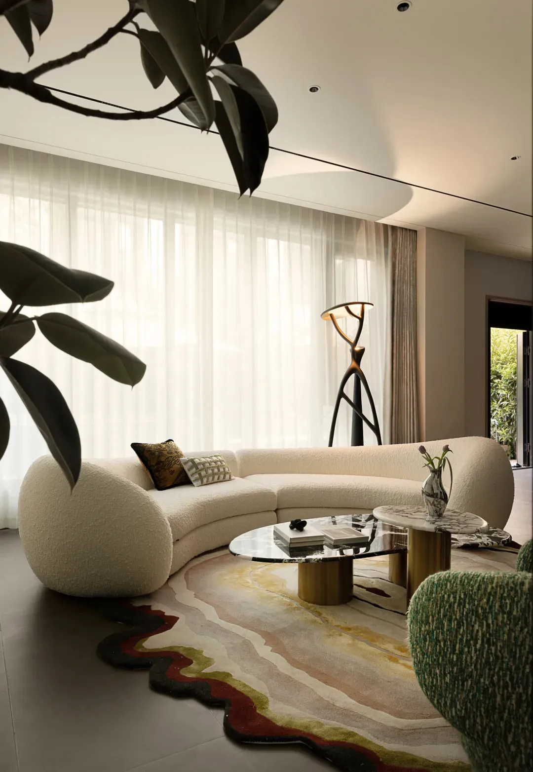 Cozy living room with a white couch, potted plants, a vase, and a chair, set against a neutral background