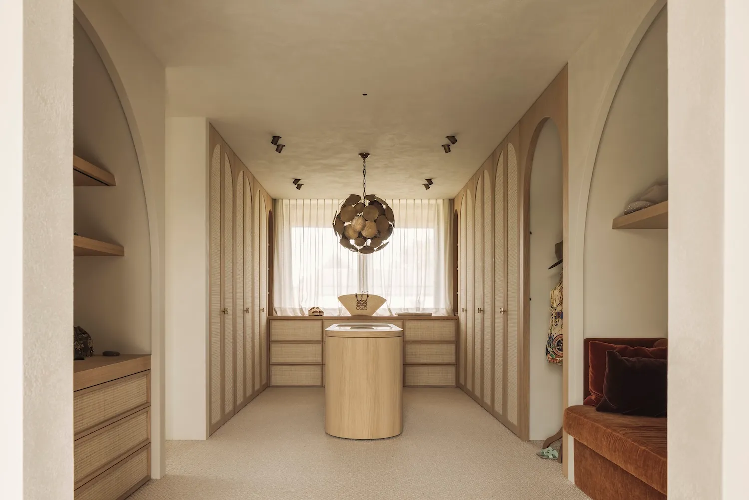 Bathroom with wooden floors and walls, natural light, and a chandelier, creating a clean and inviting atmosphere