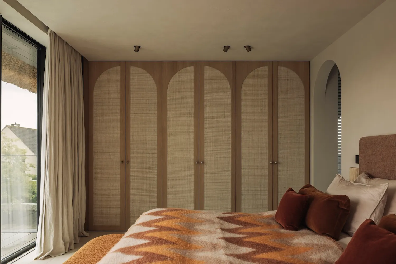 Cozy bedroom with a large bed, two wooden wardrobes, and dim lighting