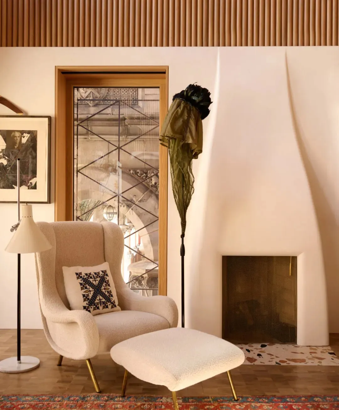Cozy living space with a white chair, two couches, a vase, and a fireplace