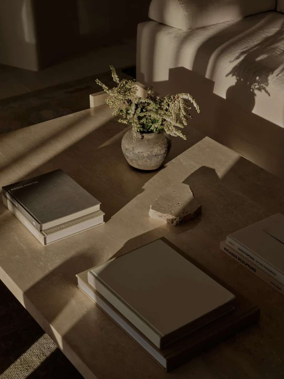 Cozy living area with a coffee table featuring several books and a vase, suggesting a love for reading in a warm and inviting space