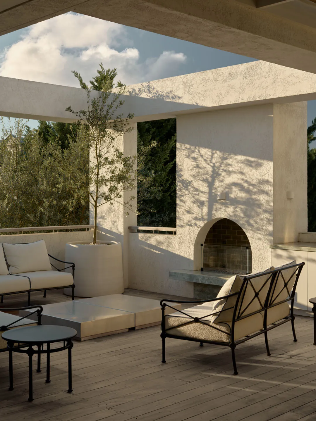 An inviting outdoor living area with a white fireplace, large window, and comfortable seating options, featuring a potted plant and a relaxed atmosphere