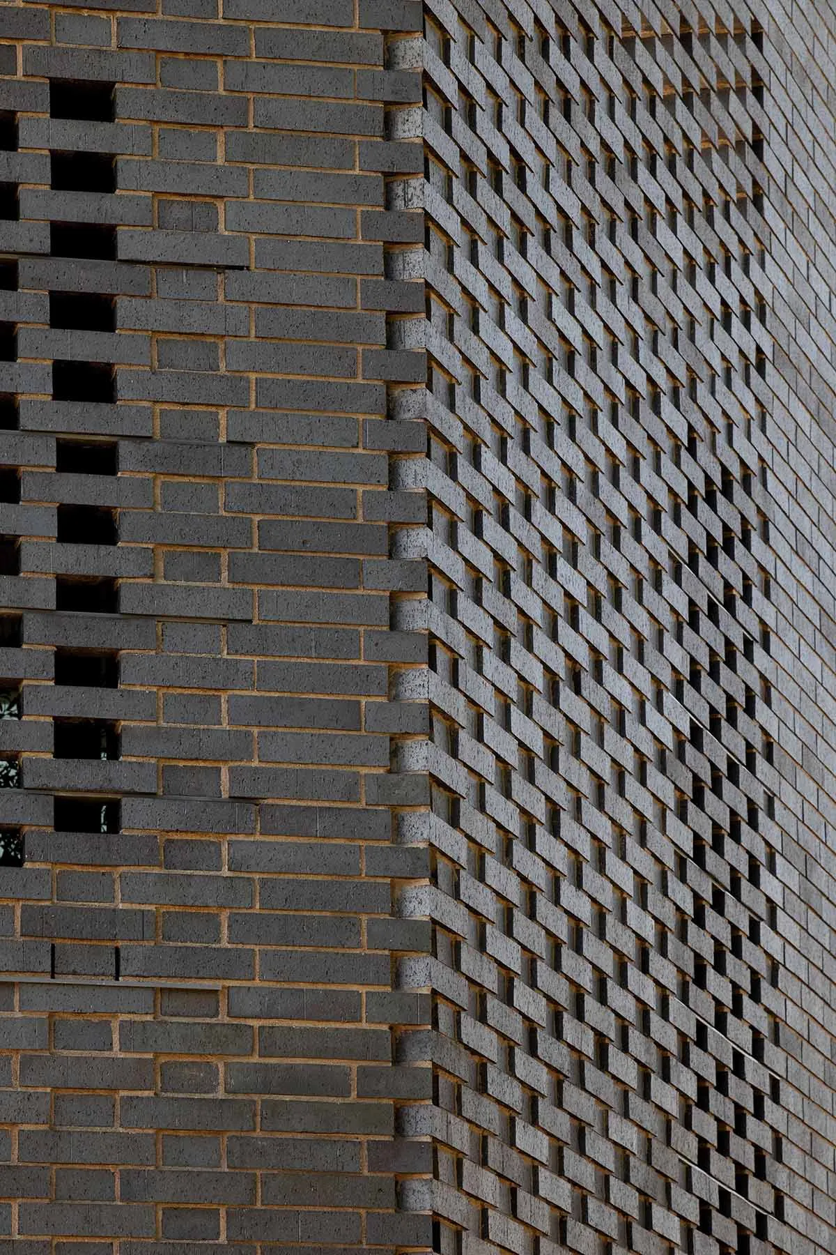 A brick wall with a unique pattern of bricks, made of stone, on a building's exterior