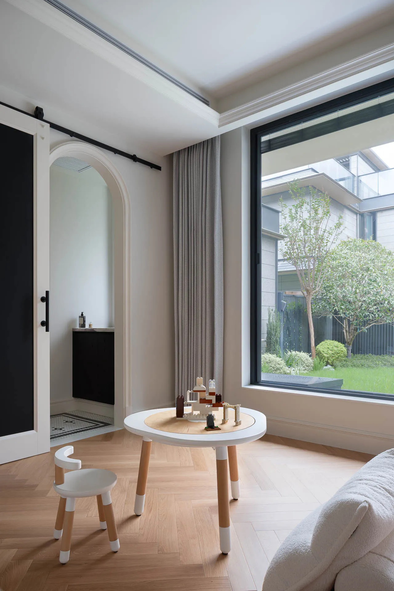 Well-lit modern living area with white interior design, wooden floor, natural light, and furniture