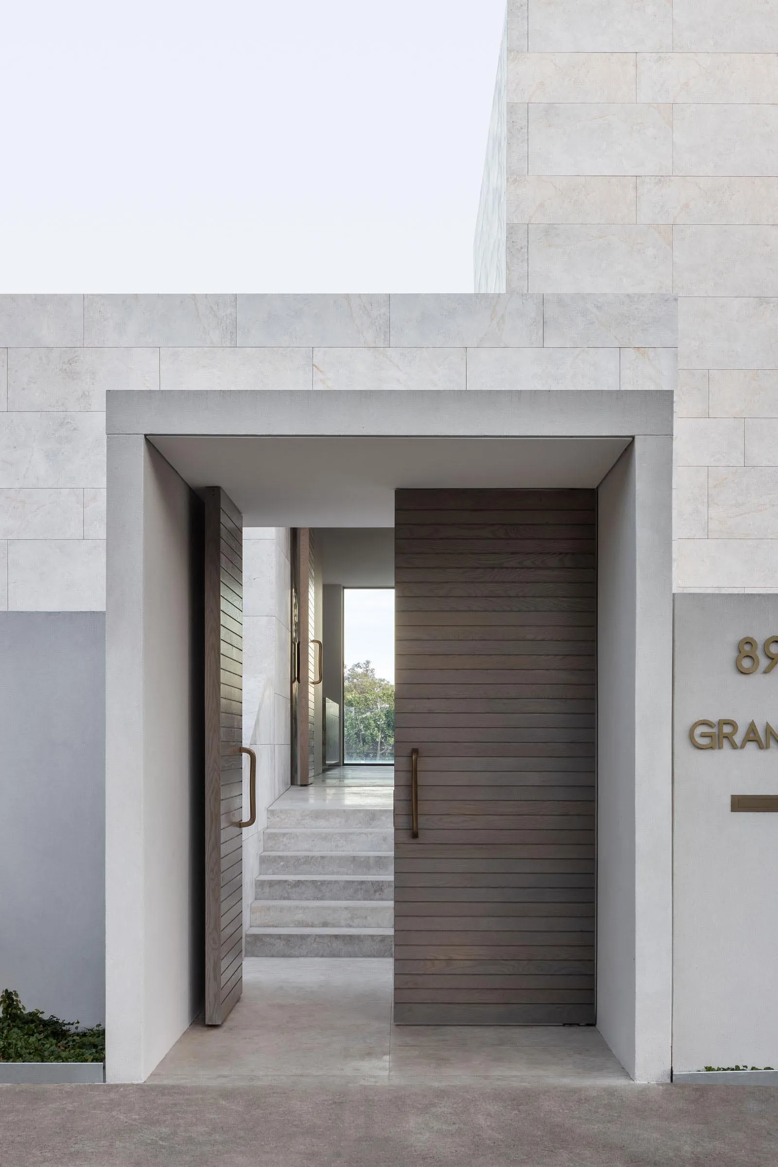 A traditional entrance with a wooden door, stairs leading upwards, and a sense of depth created by well-lit staircases