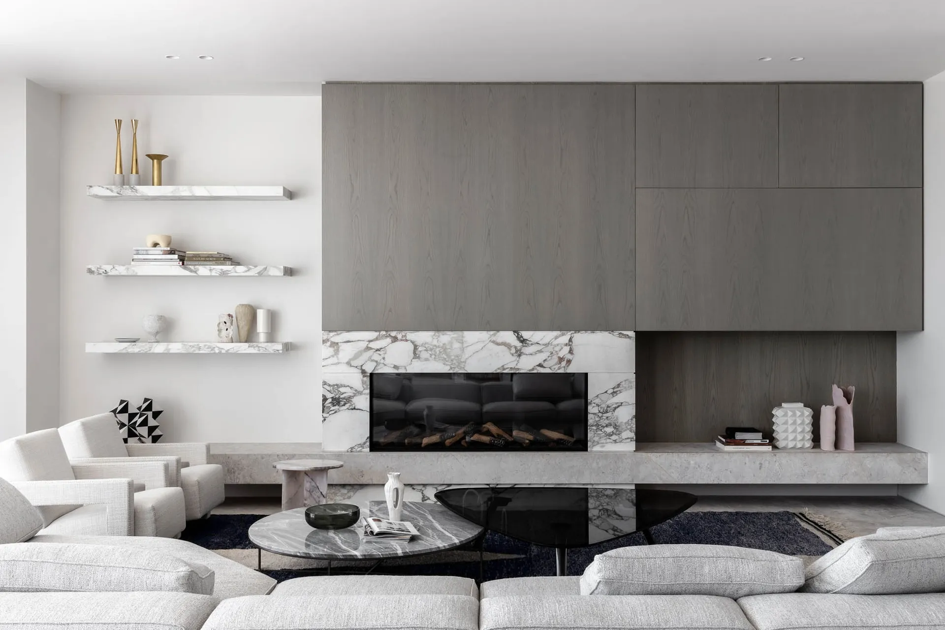 Cozy modern living space with a fireplace, comfortable seating, and books, surrounded by clean lines and minimalistic decoration